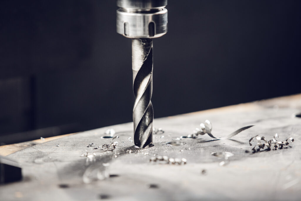Close-up of metal drilling machine. Drilling the under bolt hole.